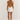Backless white mini dress with pleated skirt and pearl straps, worn by a model showing the outfit's elegant party wear design.