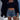 Beige knit crop top worn by a smiling woman, styled with white shorts, showcasing a chic summer fashion look.