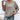 Woman wearing a beige ribbed knit pullover sweater, paired with jeans.