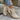 Beige suede women's ankle boots with a low heel and zipper, showcased on a model's legs.
