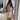 Beige sleeveless V-neck romper with a belted waist, designed for women's summer fashion.