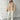 Beige women's oversized fleece bomber jacket with a trendy winter fashion design, featuring a cozy collar and long sleeves, worn by a model accessorized with sunglasses.