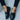Women wearing black crocodile loafers, luxury designer slip-on shoes, paired with a stylish grey dress.