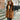 A woman wearing a black faux fur hooded vest, showcasing elegant winter fashion. The vest features plush fur material and covers her shoulders and waist, styled with an emphasis on a cozy yet stylish look.