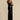 A black floral sheer one-shoulder evening dress featuring elegant floral patterns, showcasing a fitted waist and a flowing gown design.