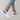 Black leopard print women's sneakers worn with denim jeans, showcasing a stylish and comfortable footwear design.