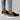 Black leopard print women's stylish comfortable sneakers displayed on a grey denim background.