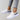 Black leopard print women's sneakers with a stylish and comfortable design, shown on a person wearing denim jeans.