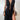 Black sleeveless maxi dress with a plunging neckline and high-slit, worn by a model showcasing an elegant evening wear style.
