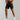 Black men's athletic gym shorts, lightweight and quick-dry, shown worn on a model, highlighting moisture-wicking fabric and fit around the thighs and knees.
