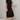 Woman wearing a black midi dress with a side slit, casual street style, short sleeves, paired with footwear.