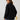 Woman wearing a black oversized denim jacket with cropped design, showcasing casual streetwear fashion.