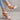 Black peep-toe heels with a low heel, showcasing the shoe's design on a model's foot, perfect for summer and suitable for both casual and bridal occasions.