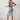 Black ribbed midi dress with a square neck and side slit, featuring a form-fitting design that accentuates the shoulders and legs.