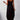 A woman standing and wearing a black sleeveless maxi dress with side pockets, showcasing a casual ankle-length fit.