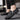 Black textured leather slip-on loafers with zipper for men, featuring a sleek design, shown worn on a human leg with a formal dress style suitable for fashion-forward occasions.