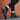 Black urban high-top sneakers on a person wearing denim jeans, showcasing stylish and durable men's streetwear footwear.