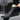 Black urban high-top sneakers worn by a person with denim jeans, showcasing stylish and durable men's streetwear footwear suitable for outdoor and casual activities.