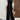 Black velvet sleeveless jumpsuit with wide legs and a smocked bodice, designed for a fashionable and elegant look.
