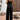 Black velvet sleeveless wide-leg jumpsuit with a smocked bodice, featuring a fitted waist and a one-piece design.