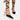 Black and white lace-up open toe espadrilles worn by a woman, showcasing the summer sandal design on her feet and legs.