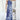 Woman wearing a blue bohemian sleeveless tie-dye jumpsuit, suitable for summer beachwear.