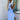 Blue striped sleeveless wrap dress worn by a woman smiling with sunglasses, showcasing a casual summer beachwear style.