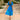 Blue tropical chiffon midi V-neck beach dress for women displayed on a mannequin, featuring short sleeves and a fitted waist, set against a lush, natural backdrop suggestive of a summer setting.