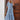 Woman wearing a blue and white V-neck boho maxi dress ideal for lightweight summer beachwear, paired with sunglasses.