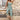 Bohemian Floral Wide-Leg Jumpsuit featuring a relaxed fit with wide legs and floral pattern, worn by a woman accessorized with a fedora, captured indoors near a window.