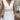 White lace summer dress featuring a bohemian style with a V-neck design, showcasing elegant sleeves and intricate embellishments.