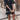 Boho-Chic V-Neck Mini Dress in a black and white pattern, featuring a flowing design with a fitted waist and sleeves. The dress is styled as a summer dress and beach cover-up, ideal for warm weather outings. The dress is presented on a model, showcasing its flattering V-neckline and short hemline.