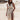 Boho Chic White Lace Maxi Dress worn by a smiling woman outdoors, showcasing the dress's elegant design with lace detailing, fitted waist, and flowing skirt. The dress has short sleeves and is suitable for summer beach weddings.