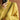 Woman wearing a bright yellow geometric knit high neck sweater, accessorized with sunglasses, in an outdoor winter fashion photoshoot.
