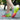 Colorful women's running shoes displayed in a vibrant pink and magenta color, designed for lightweight and breathable performance, shown on a person's leg in a natural setting.