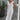 Elegant white linen V-neck summer dress on display, complemented with a pearl necklace.