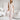 Elegant white sleeveless V-neck belted formal jumpsuit for women displayed on a mannequin.