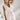 Woman wearing an elegant white sleeveless V-neck belted formal jumpsuit