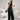 Elegant white sleeveless V-neck belted formal jumpsuit for women, showcasing a stylish and comfortable design with emphasis on the neck, waist, and thigh areas.