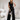 Elegant white sleeveless V-neck belted formal jumpsuit for women, showcasing a stylish and sophisticated design, modelled by a woman with black hair.