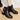 Elegant women's black leather ankle boots showcasing chic winter style, worn on a model's legs with a focus on the fashion design and leather material.