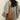 Elegant women's pale green leather mini backpack with stylish design, shown hanging from a woman's shoulder against a neutral background.