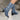 Floral blue denim ankle boots with block and high heels worn by a model, showcasing the stylish design and vibrant electric blue color.