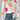 A vibrant floral knit sweater designed for women's autumn and winter fashion, featuring a cozy fit. The sweater has a textured textile pattern, long sleeves, and a comfortable collar. It is paired with jeans, showcasing a stylish and fashionable casual look.