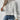 Woman wearing a Floral Wool High-Neck Sweater in Cozy Gray, paired with jeans, showcasing winter knitwear fashion.