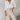 A pair of women's geometric high waist beige trousers displayed in a fashion-forward setting, showcasing the elegant design and tailored fit around the waist and thighs.