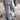 Gray oversized ribbed knit sweater on a woman, showcasing its cozy, casual design perfect for winter wear. The sweater features long sleeves and a soft, comfortable fit, with the fabric draping over the waist and hips. The color is a versatile grey, suitable for pairing with various outfits.