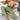 Woman wearing a green ribbed lace trim jumpsuit, showcasing comfortable loungewear with short sleeves and a fitted waist.