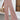 Woman wearing high-waisted pleated pink trousers, showcasing lightweight summer pants.