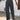 Woman wearing high-waisted pleated pink trousers, standing with hands in pockets, showcasing lightweight summer fabric and tailored fit around waist, thighs, and knees.